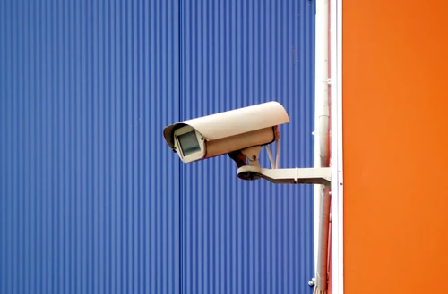 utdoor security camera mounted on building wall near storage units.