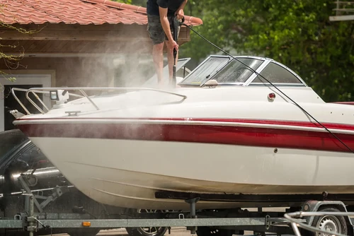 Man washing boat on trailer as part of long term storage preparation.