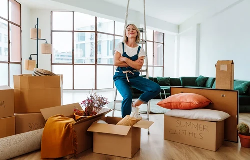 Woman organizing boxes and decluttering home during summer clean out.