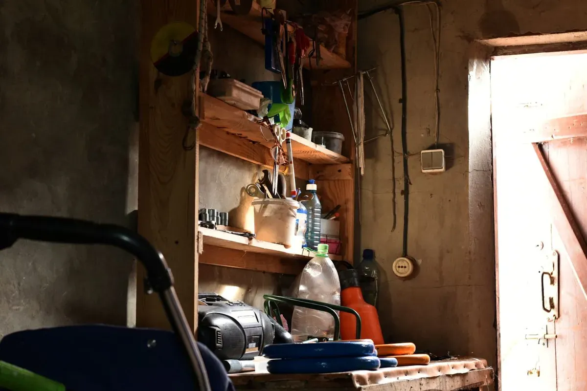 A shelving unit in a shed and a tool are illuminated by a beam of light.