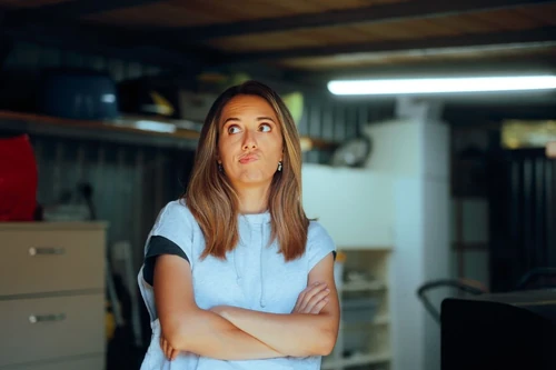 Woman thinking how to declutter a garage.